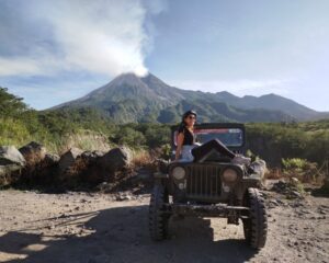 Posing on a Willys Jeep in front of Merapi volcano